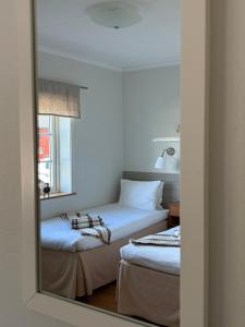 two beds in a room with a mirror at Närebo Gårdshotell in Lidköping