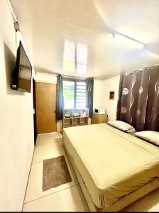 a small bedroom with a bed and a television at Ritualodge in Bora Bora