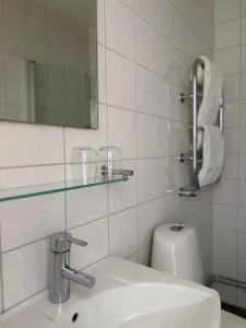 a bathroom with a sink and a mirror and a toilet at Närebo Gårdshotell in Lidköping