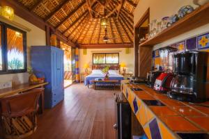 a kitchen with a counter and a living room at Hotel Casamar Suites in Puerto Escondido