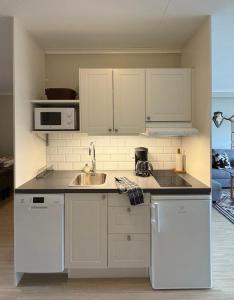 a kitchen with white cabinets and a sink at Närebo Gårdshotell in Lidköping