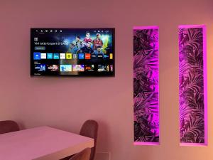 a tv hanging on a wall in a room with a table at Residenza del Lago in Viverone