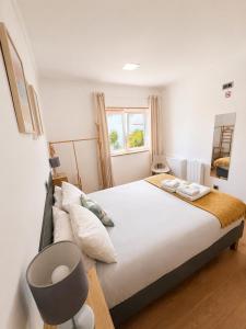 a bedroom with a large bed and a window at Like a Local Guest House in Ericeira +79 photos