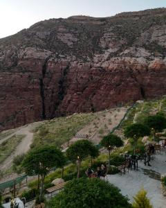 people sitting at tables in front of a mountain at Dana Trail Hotel in Dana