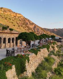a group of tables and chairs in front of a mountain at Dana Trail Hotel in Dana