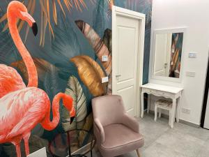 a room with a chair and a painting of flamingos at Residenza del Lago in Viverone