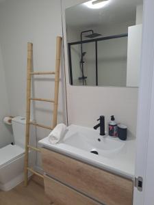 a bathroom with a sink and a mirror and a toilet at Costa Canido I in Malpica +16 photos