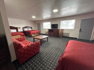 a hotel room with two beds and a chair at Rodeway Inn Flora in Flora
