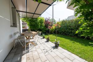 a patio with a table and chairs under an umbrella at La casa di Guido in San Giovanni in Marignano