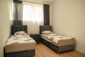 two twin beds in a room with a window at PIK Residence in Mostar +76 photos