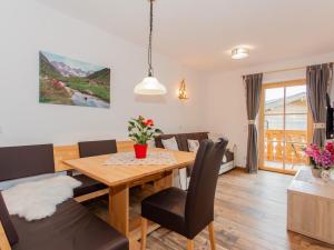 a dining room and living room with a table and chairs at Das Rendlgut Top 3 in Lofer +6 photos