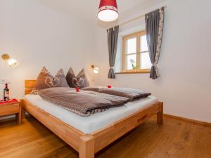 a bedroom with a wooden bed with pillows at Das Rendlgut Top 3 in Lofer