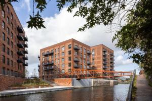 a bridge over a river with two buildings at Modern Townhouse Birmingham in Birmingham +11 photos