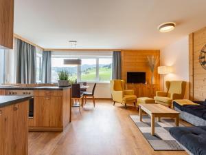 a kitchen and living room with yellow chairs and a table at Pabstin in Sankt Lambrecht