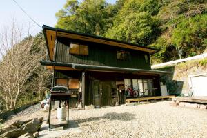 a small green building with a bench in front of it at Kizuna Guesthouse in Kizugawa