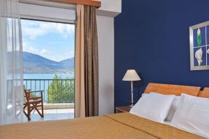 a bedroom with a bed and a large window with a view at Lucy Hotel in Chalkida