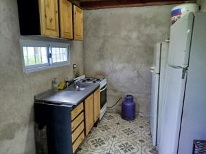 a kitchen with a sink and a stove and a refrigerator at Sierras Cosquin in Cosquín +12 photos