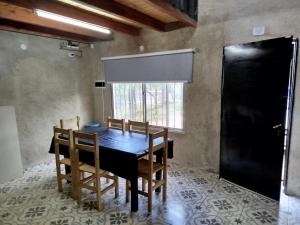 a dining room with a black table and chairs at Sierras Cosquin in Cosquín