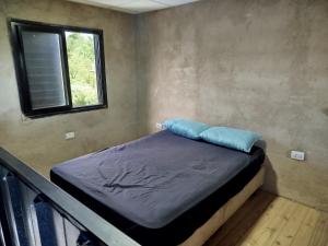 a small bed in a room with a window at Sierras Cosquin in Cosquín