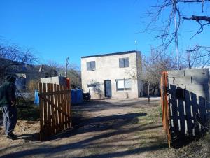 a man standing behind a gate in front of a house at Sierras Cosquin in Cosquín