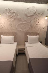 two beds in a room with flowers on the wall at Italy hotel in Silifke +13 photos