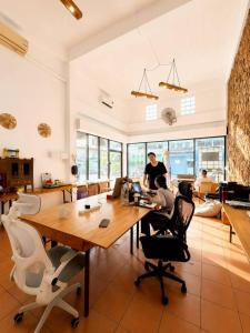 a group of people working at a table in an office at Youyen Hostel in Ban Don Muang (1)