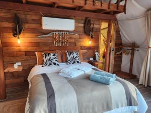 a bedroom with a large bed with wooden walls at Alma Lemu Lodge in Los Ladrillos