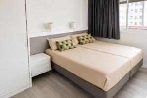 a bedroom with a bed with two pillows and a mirror at Gran Rapido - Modern 1 bedroom apartment very close to Yumbo in Playa del Ingles +18 photos