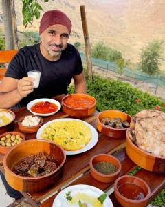 a man sitting at a table full of food at Dana Trail Cottages in Dana +88 photos