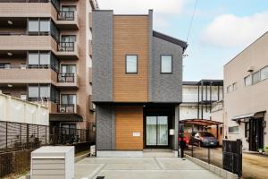 a contemporary house with a black and wood facade at AsobiStay児玉藤 in Nagoya