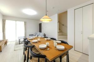 a dining room with a wooden table and chairs at AsobiStay児玉藤 in Nagoya