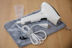 a hair dryer sitting on a towel with a glass at AsobiStay児玉藤 in Nagoya