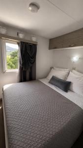 a large bed in a room with a window at Glykofilousa Tiny Ηouse in Petra
