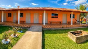 an orange house with a garden in front of it at Pousada Serra Dourada Mossâmedes in Mossâmedes