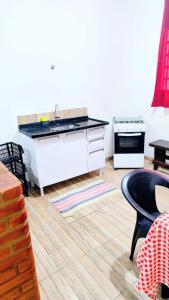 a kitchen with a sink and a stove at Recanto das Termas, Chalés in Termas do Ibirá