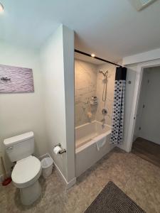 a bathroom with a toilet and a bath tub at Private Guest Suite In Colwood in Colwood +6 photos