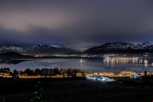 a view of a lake at night with snow covered mountains at Romantic Spa del Lago in Viverone