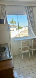 a kitchen with a window with a view of the beach at Loft Pedra Branca - Unisul in Palhoça