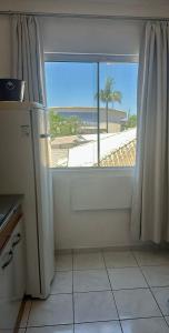 a kitchen with a door with a view of the beach at Loft Pedra Branca - Unisul in Palhoça