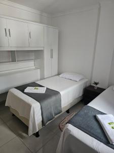 a bedroom with two beds and white cabinets at Zanotti's House in Santa Teresa