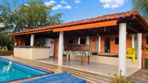 a house with a swimming pool and a patio at Pousada Serra Dourada Mossâmedes in Mossâmedes