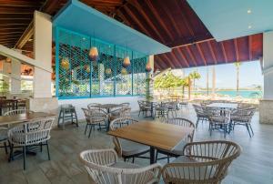 a restaurant with tables and chairs and a view of the ocean at Oceanfront Paradise Beach Resort Escape in San Felipe de Puerto Plata