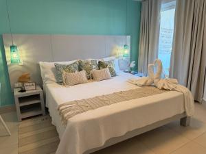 a bedroom with a large bed with pillows at Oceanfront Paradise Beach Resort Escape in San Felipe de Puerto Plata +73 photos