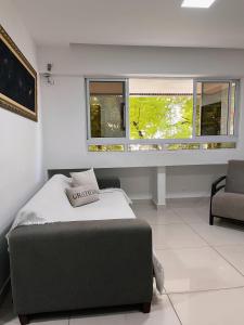 a bedroom with a bed and a desk and two windows at Prédio Solar do Atlântico, apt 204 - Apartamento lateral em Tambaú in João Pessoa +33 photos