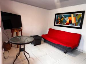 a small room with a red couch and a tv at La TOLVA Café & experiencia in Pijao