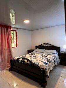 a bedroom with a bed with a black and white comforter at La TOLVA Café & experiencia in Pijao