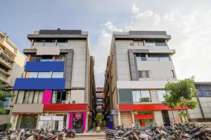 two tall buildings with motorcycles parked in front of them at Hotel O Maple view in Naroda +27 photos
