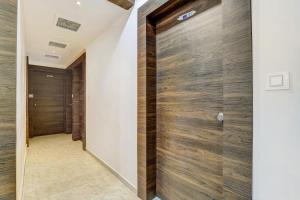 a pivot door in a hallway with wood at Hotel O Maple view in Naroda