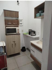 a small kitchen with a sink and a microwave at Studio Apto Central próximo a Orla in Fatima do Sul