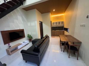 a living room with a couch and a table and a television at Omah Tentrem Magelang in Magelang
